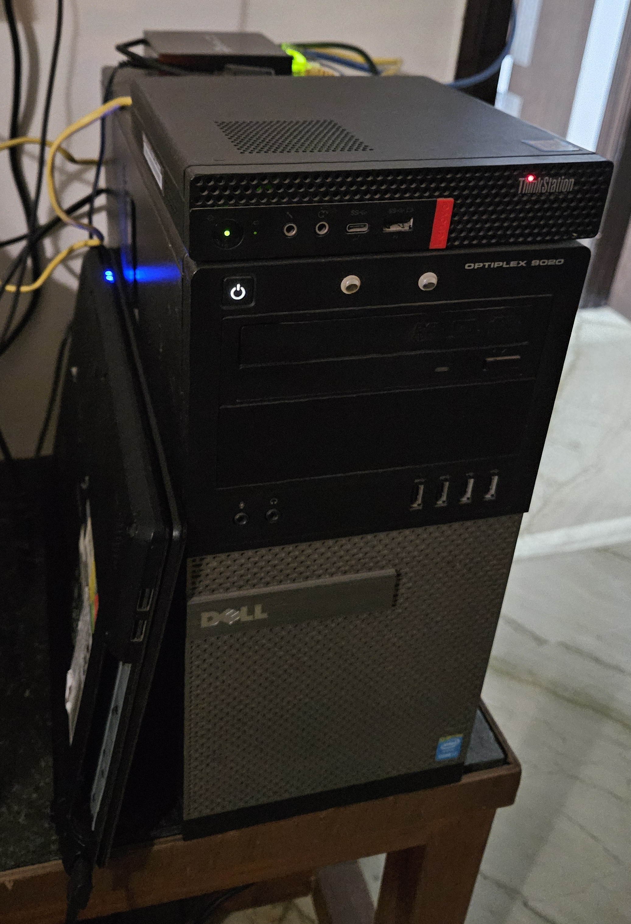 A front-facing image showing the cluster, with the mini PC, Cabinet and laptop huddled together. The mini PC sits on top of the cabinet, and the laptop rests to its side. There are googly eyes stuck onto the cabinet PC.
